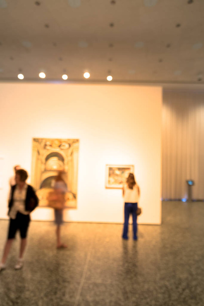 アメリカの美術館で美術品の展示を見ているフィルタリングされた画像ぼやけ背景の人々 - 写真・画像