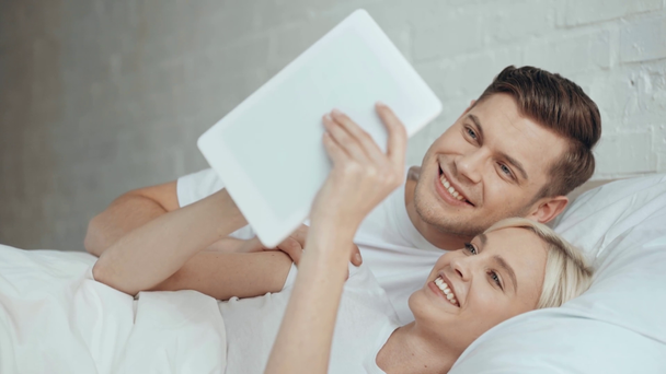 belo casal conversando, sorrindo e usando tablet digital na cama
 - Filmagem, Vídeo