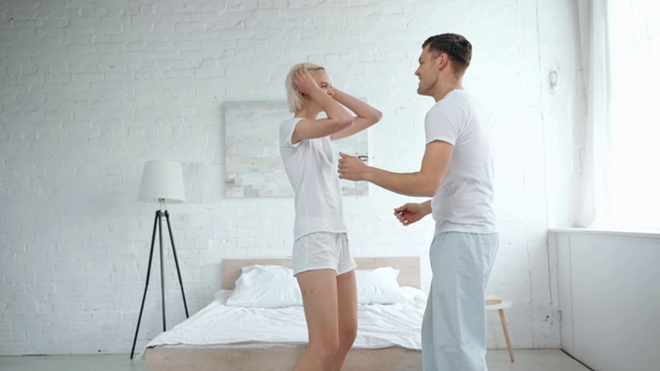 szép boldog fiatal pár tánc-és csók a hálószobában - Felvétel, videó