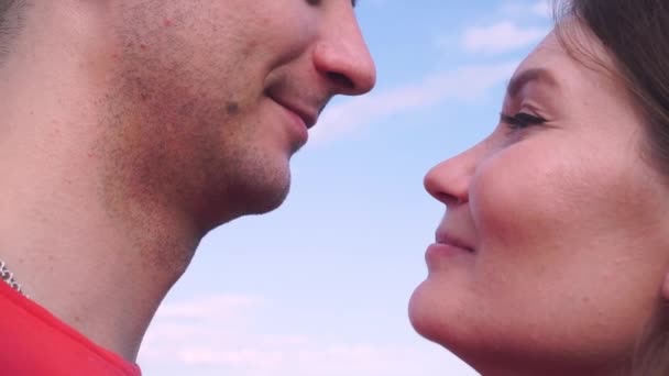 close up, young boy and girl kiss gently against the sky - Footage, Video