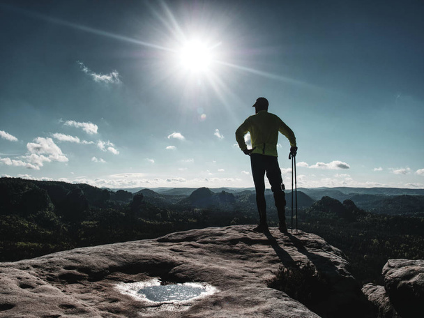 Atleta uomo corridore con bastoni da trekking che corre sentiero roccioso
  - Foto, immagini