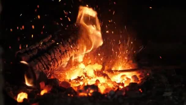 Büyük gözlü eski bir ruh gibi görünen ateş çatalları ile üretim demir güller ve at nalı için harap bir ocak bir demirci bir ruh gibi görünen bir dil ile öfkeli fırın yangın - Video, Çekim
