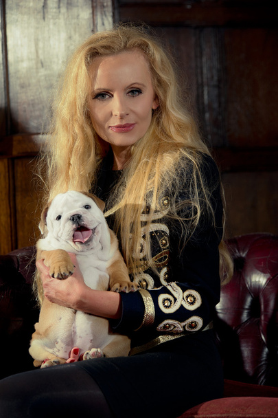 Blonde woman with a puppy in luxury room - Zdjęcie, obraz