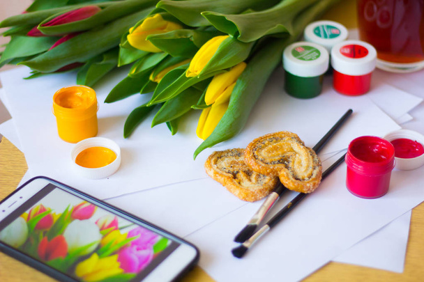 Tulipes, papier, pinceaux et peintures gouache. Dessinez un concept de carte postale du 8 mars. Vacances avec les femmes
 - Photo, image