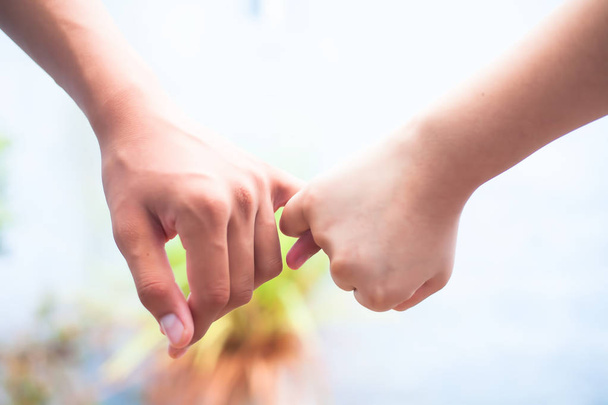 Female child's hand holding the hand of elder male shot with bokeh background and horizontal. Concept of father's day ( 16th June). - Foto, imagen