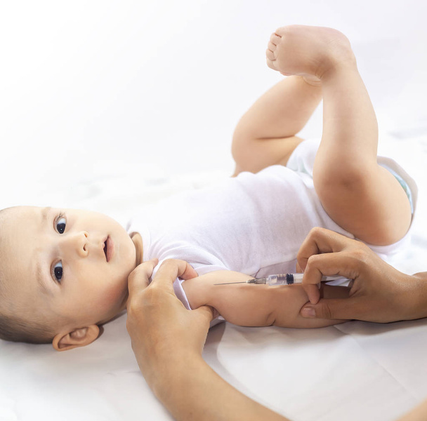 Orvos himlőoltás egy újszülött fiút. Gyermek immunizálás, gyermek védőoltás, egészségügyi koncepció. - Fotó, kép