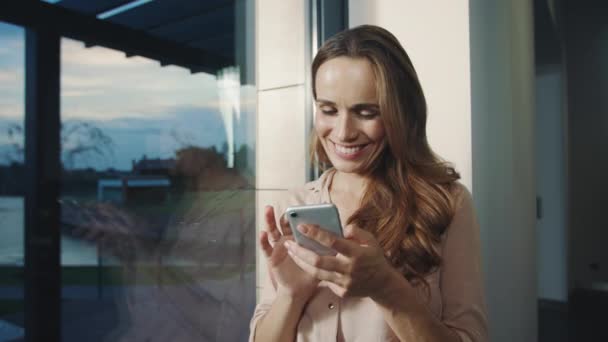 Ontspannen vrouw krijgt grappige boodschap op mobiel. Gelukkige vrouw chatten op mobiele telefoon - Video