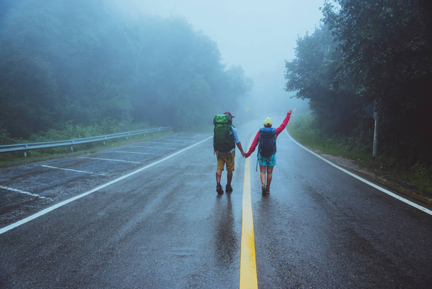 Ο εραστής της Ασίας και οι ασιατικές γυναίκες ταξιδεύουν στη φύση. Περπατήστε στην πορεία. το ταξίδι της φύσης ευτυχισμένα. Μέσα στην ομίχλη που βρέχει. στην εποχή των βροχών. - Φωτογραφία, εικόνα