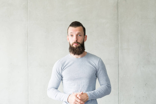 sceptic bearded hipster guy gray wall background - 写真・画像