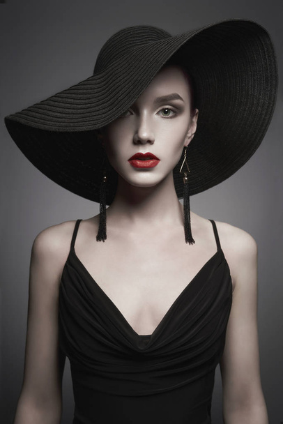 黒い帽子とイブニングドレスを着た若い女性の肖像画 - 写真・画像