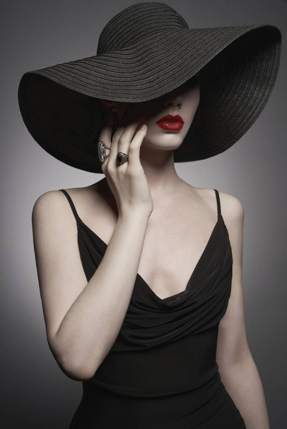 portrét mladé dámy s černým kloboukem a večerním oblečem - Fotografie, Obrázek