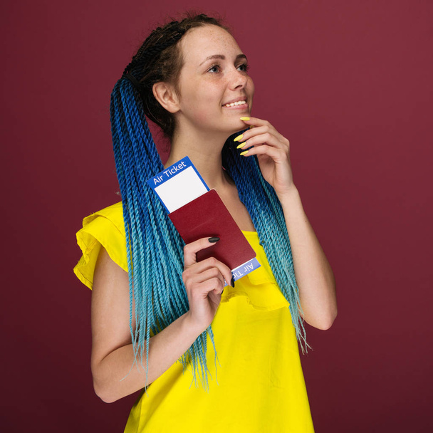 Современная модная улыбающаяся женщина в желтом платье с авиабилетами и паспортом в руке. Концепция путешествия
 - Фото, изображение
