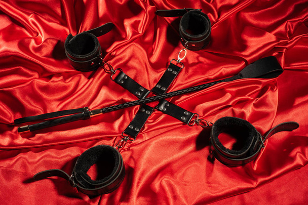 Top view of bdsm outfit. Bondage and spank on the red linen. Adu - Fotoğraf, Görsel