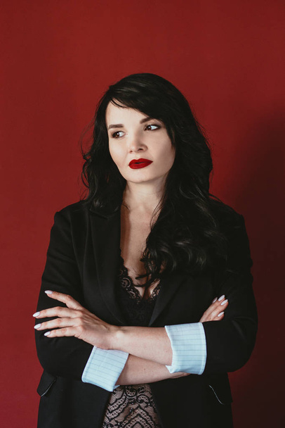 portrait of brunette business woman in suit on red background - Foto, afbeelding