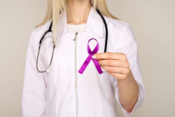 Женщина-врач в белой форме с фиолетовым осознанием ленты i
 - Фото, изображение