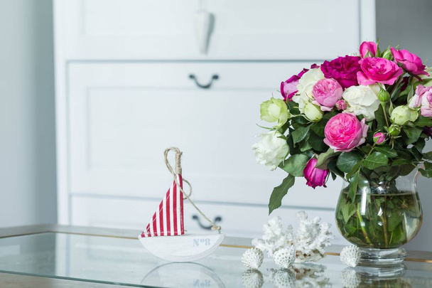 Интерьер в стиле Хэмптон - свежие цветы, раковины, украшения парусника
 - Фото, изображение