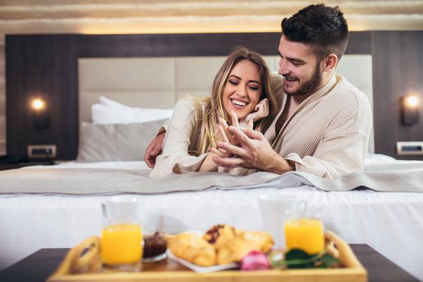 Young happy couple having breakfast in luxury hotel room.  - Фото, зображення