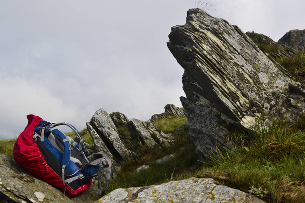 Zaino sul sentiero escursionistico tra rocce in montagna senza viaggiatori
 - Foto, immagini