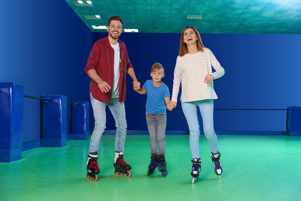 Happy family having fun at roller skating rink - 写真・画像