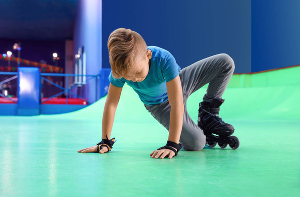 Boy falling down at roller skating rink - Fotoğraf, Görsel