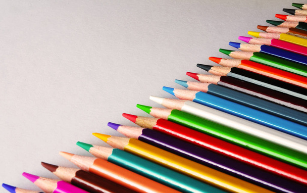 красочные карандаши, лежащие по диагонали на белой бумаге
 - Фото, изображение