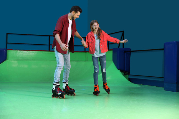 Father teaching her daughter roller skating at rink - 写真・画像