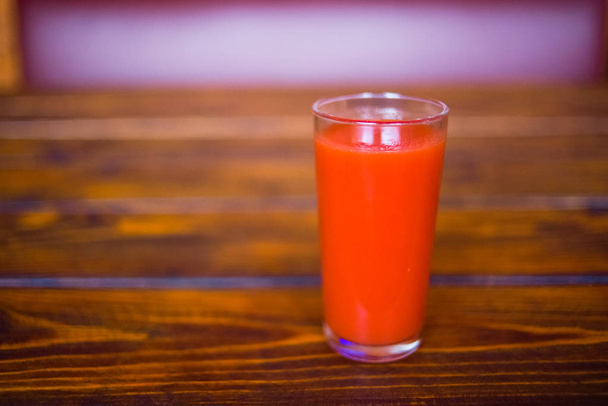 Tomaattimehua lasissa puupöydällä. Terveellisten luonnonmukaisten elintarvikkeiden käsite
. - Valokuva, kuva