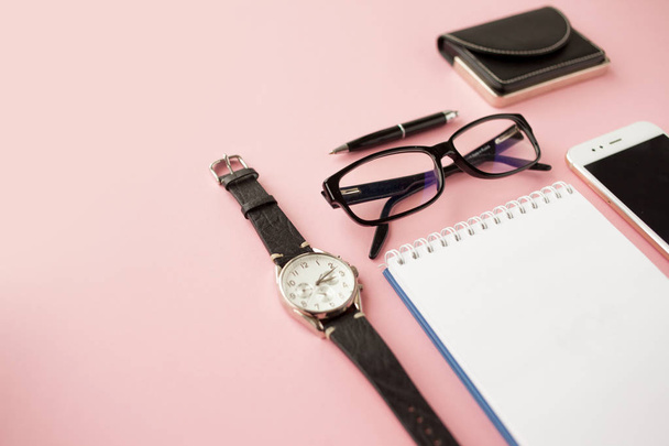Stationery, white smartphone, glasses, pen, wallet, watch, calendar, notebook. Pink background. - Photo, Image