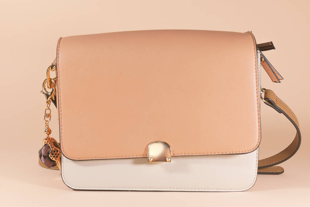 A pink and white purse is laying on a pink surface - Photo, Image