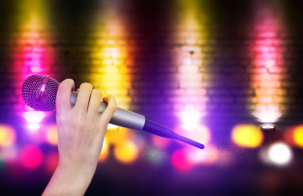 Una mano femenina sostiene un micrófono contra las luces coloridas de la escena del club de karaoke. Fondo colorido brillante con luces de neón borrosas
 - Foto, imagen