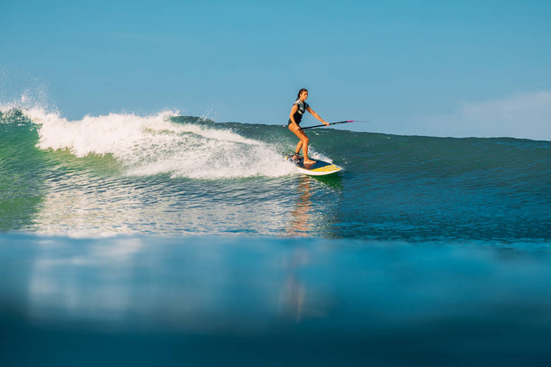 12 de abril de 2019. Bali, Indonesia. Stand Up Paddle surfista paseo en ola oceánica. Stand Up Paddle surf en las olas en Bali
 - Foto, imagen