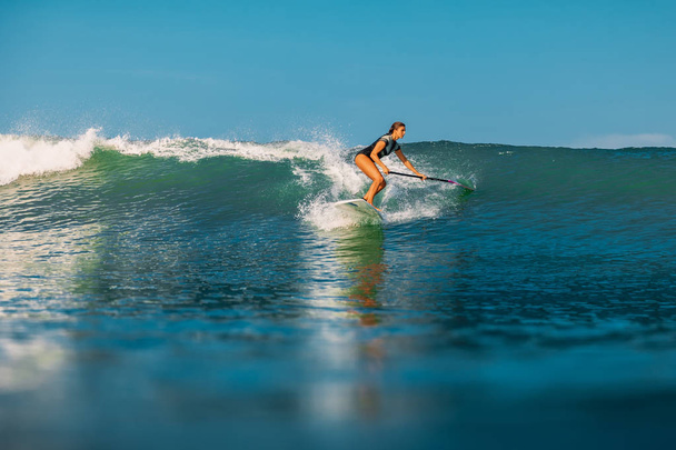 12 апреля 2019 года. Бали, Индонезия. Встань гребной серфер ездить на океанской волне. Встать весла серфинг на волнах на Бали
 - Фото, изображение