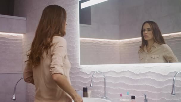 Business woman setting shirt in bathroom. Longhair lady wearing closes. - Πλάνα, βίντεο