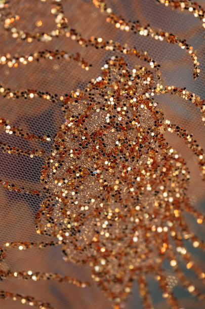 Fabric arany flitter. A textúra a fényes anyag. Dekoratív anyagból díszítve arany flitter. - Fotó, kép