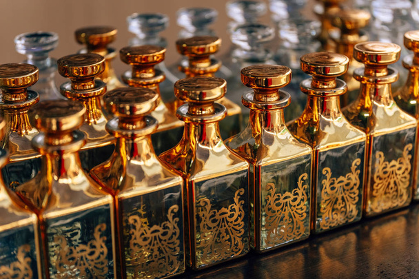 Bottiglia di vetro dorato con oli di perfumowana. Contenitori decorativi per oli e profumi. Bottiglia di vetro
. - Foto, immagini