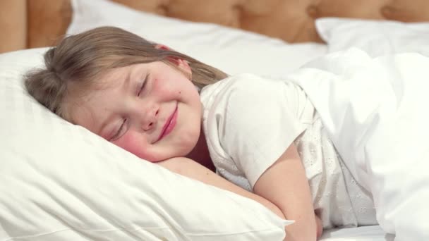 Cute little girl going to sleep in her bed, mother tucking the blanket - Video, Çekim