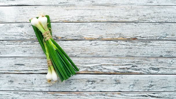 Green onion on a white wooden background. Top view. Free space for text. - Photo, Image