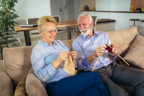 Senior woman teaching her husband the art of knitting woollen cl - Fotoğraf, Görsel