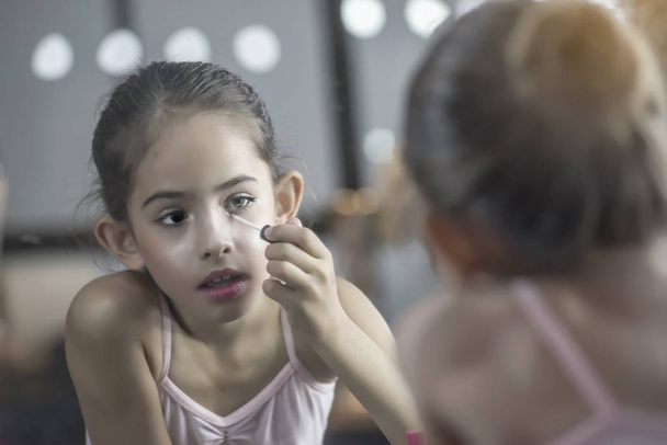 Bailarina niños preparan maquillaje, conforman su propio espejo de maquillaje en el vestidor
. - Foto, imagen