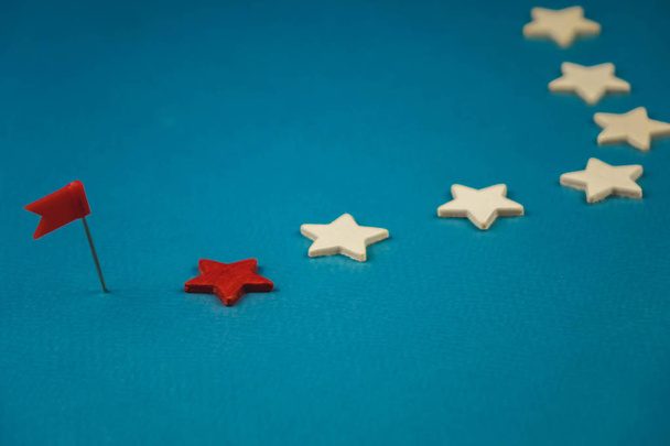 ξύλινα αστέρια και ένα κόκκινο σε μπλε φόντο με κόκκινη σημαία - Φωτογραφία, εικόνα