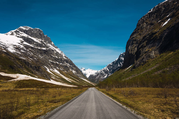 Empty straight road running between hilly picturesque rocks - Fotó, kép