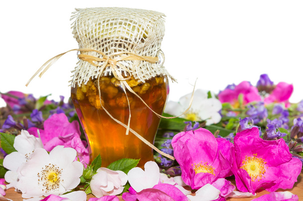 Honey jar with blossoms and herbs - Foto, Bild