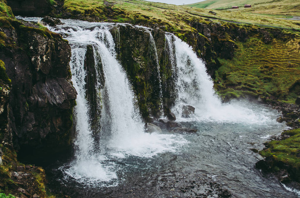 La cascada de Kirkjufell en Islandia. Agua clara cayendo en el arroyo. Hermoso paisaje en una fría tarde gris
. - Foto, imagen