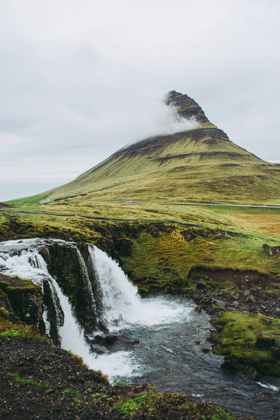 Famous view of Kirkjufellsfoss waterfall and mountain. One of the most memorable sceneries to see and experience in Iceland. - Фото, изображение