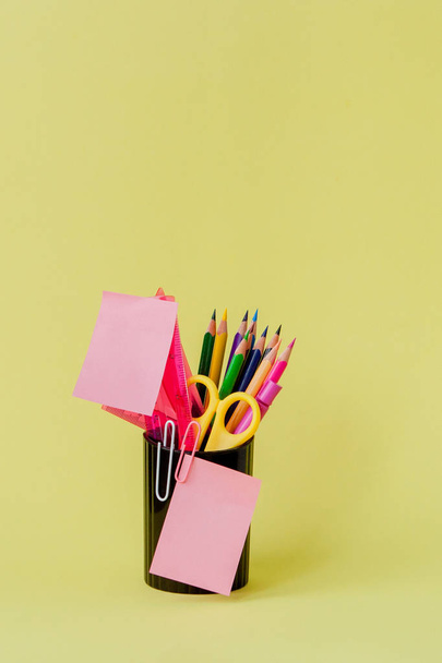 Back to school concept with space for text. Copy space. School office supplies.Creative desk with colourful stationery. Colored paper clip.School supplies on yellow background.Office desk - Foto, Bild
