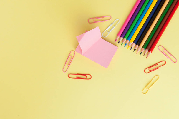 Back to school concept with space for text. Top view. Copy space. School office supplies.Creative desk with colourful stationery. Colored paper clip.School supplies on yellow background.Office desk - Foto, imagen