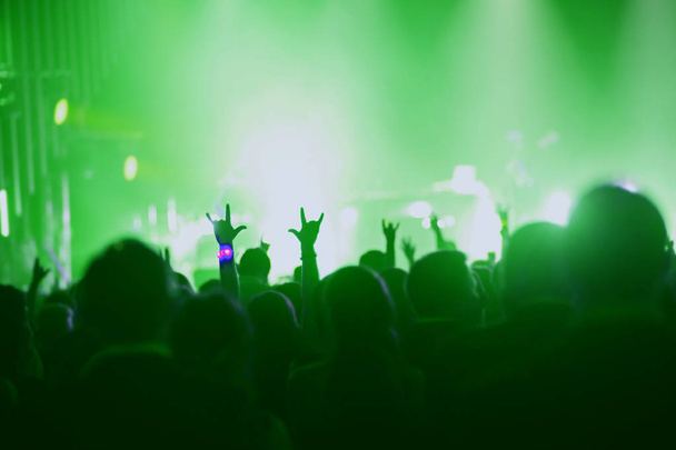 Koncert, akce nebo stranické pojetí. Lidé s rukama nahoře na scéně, reflektor, barevný zelený indikátor. - Fotografie, Obrázek