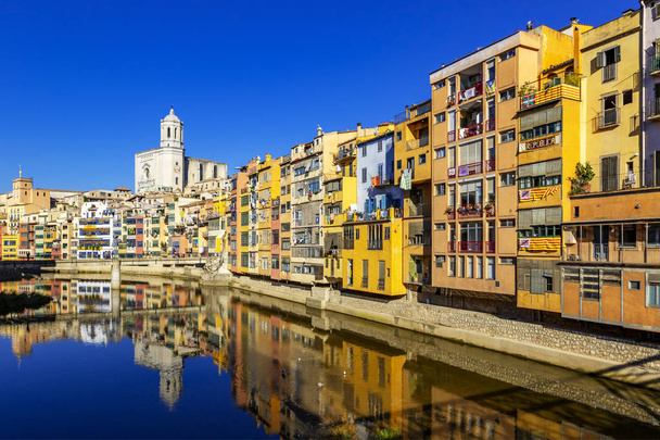 Coloridas casas amarillas y naranjas reflejadas en el agua, Girona
 - Foto, imagen