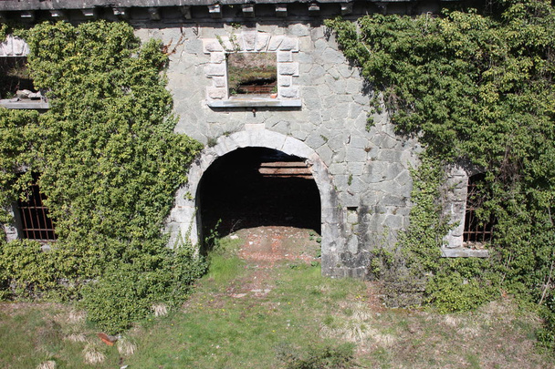 portal de acesso assustador, arqueado para entrar no Fort Bastion de Fosdinovo, uma fortaleza tomada pela natureza e vegetação selvagem
 - Foto, Imagem