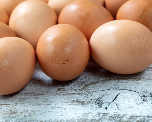 Huevos de granja marrones orgánicos crudos sobre fondo de madera rústica blanca
 - Foto, Imagen